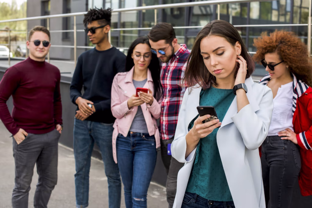 Grupo de jovens interagindo com seus celulares em ambiente urbano, ilustrando a conexão da Geração Z com o marketing digital.